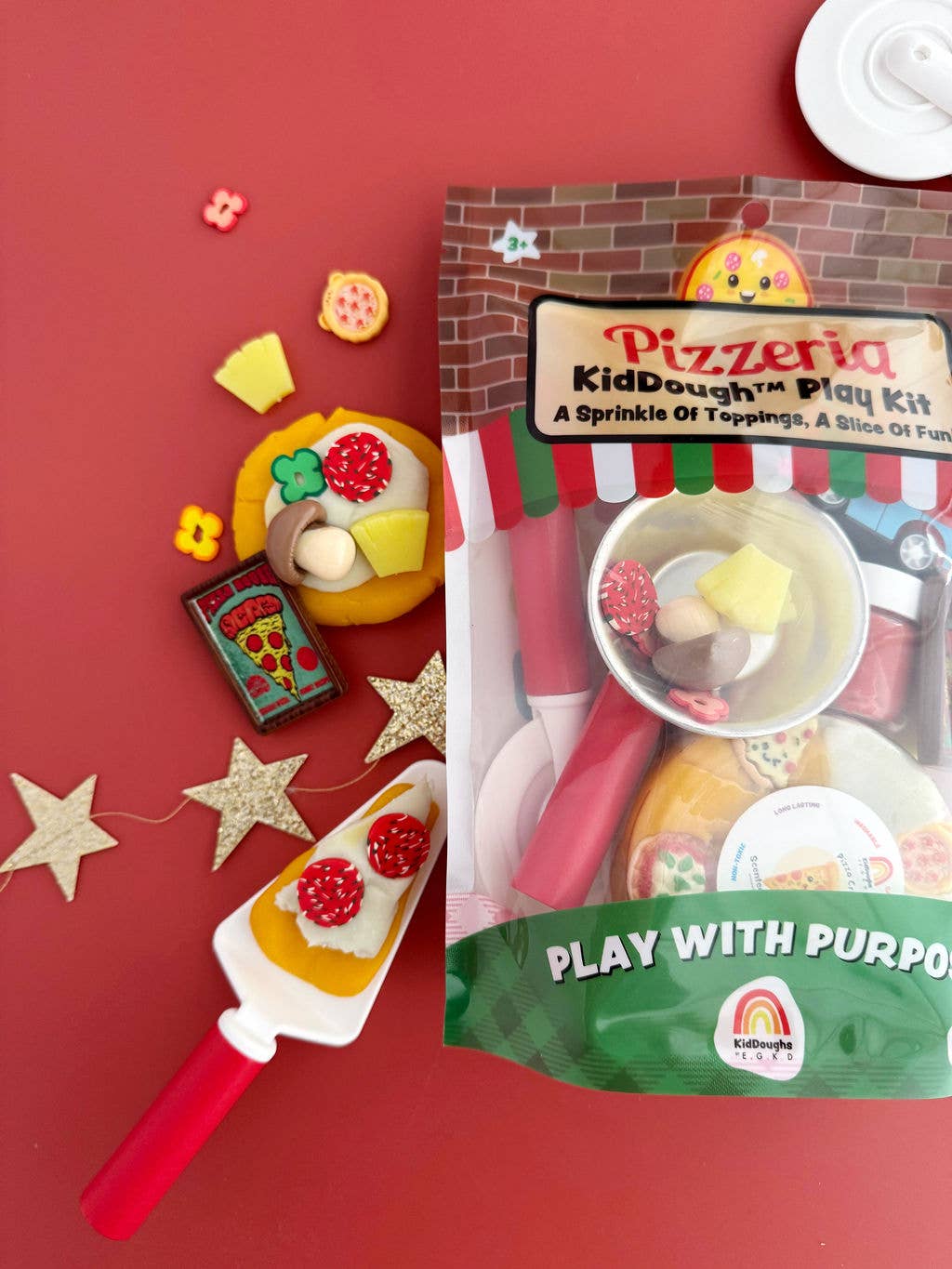 Pizzeria KidDough Play Kit with toy pizza, rolling pin, and play dough on a red background