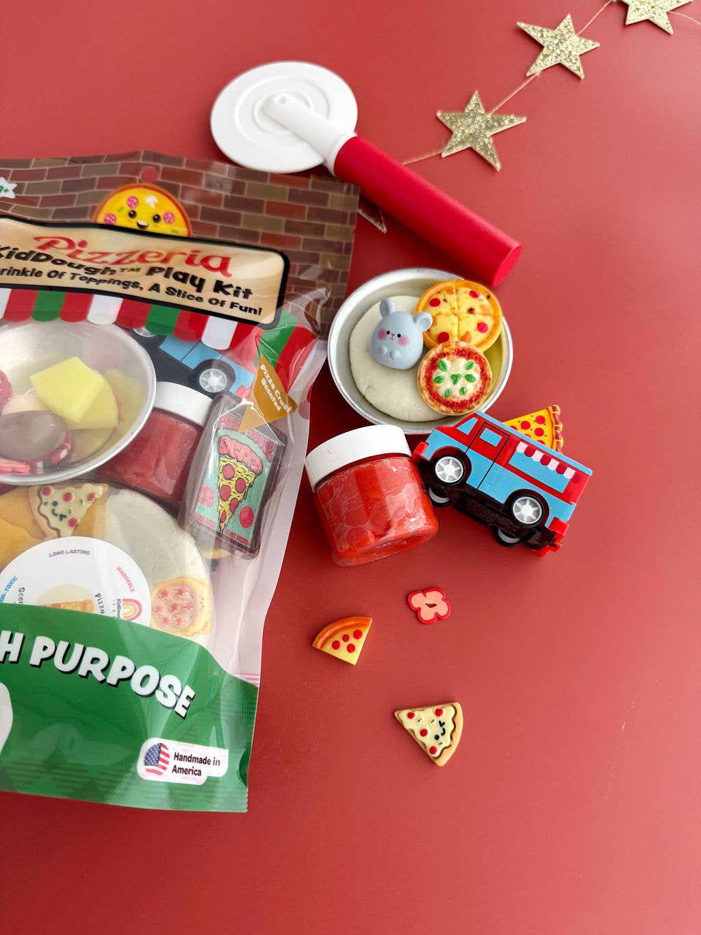 Children's play kit with pizza-themed toys on a red background