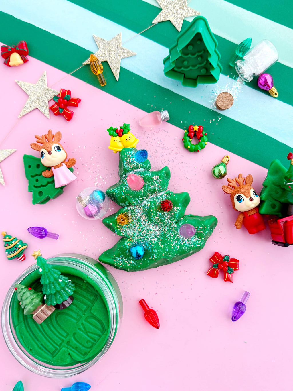 Christmas-themed play dough set with green trees, decorations, and characters on a striped background.