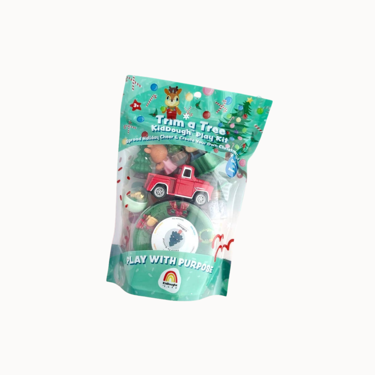 A packaged Christmas-themed toy set labeled 'Trim a Tree Kids Play Play Kit' in a clear stand-up pouch with teal holiday graphics, showing a small red toy truck and other play pieces inside.
