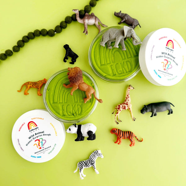 Set of animal figurines and two green containers on a yellow background