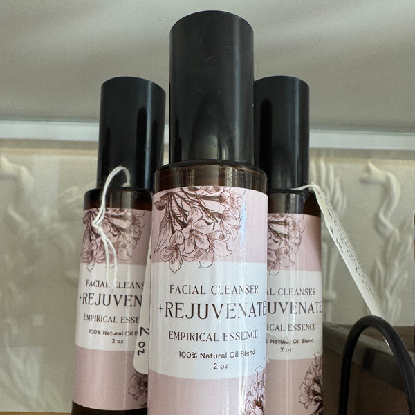 Three bottles of facial cleanser with labels on a wooden shelf.