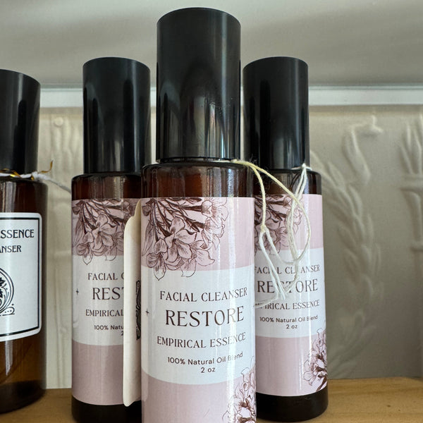 Three bottles of facial cleanser with labels on a wooden surface