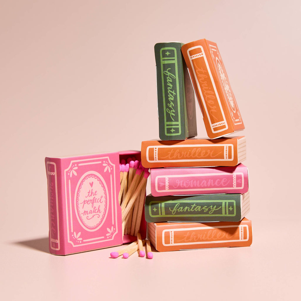 Stack of book-shaped matchboxes with matches on a beige background