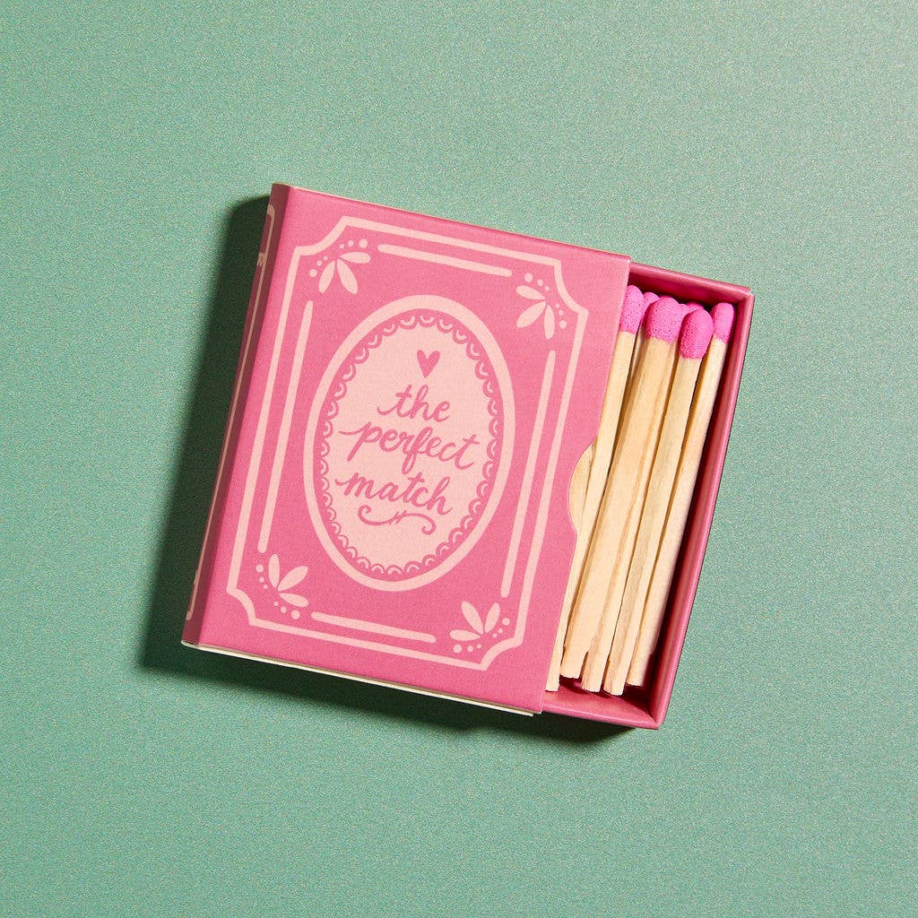 Pink matchbox with matches on a green background