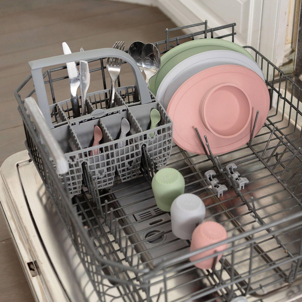 Dishwasher with a load of dishes including plates, bowls, and cutlery.
