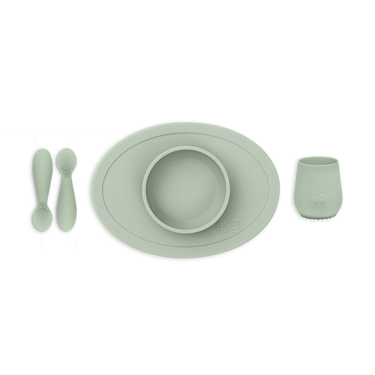 Set of green silicone utensils and placemat on a white background