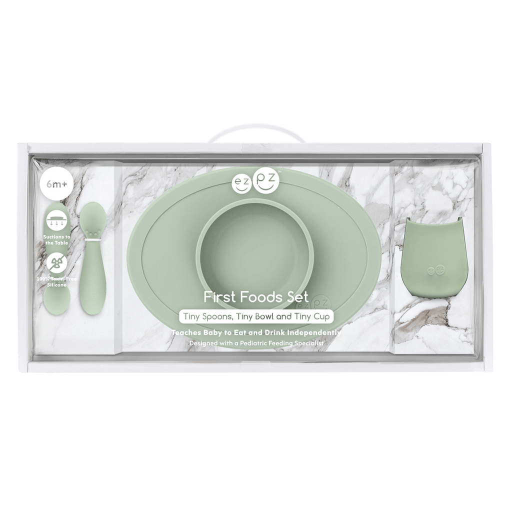 Mint green baby feeding set with bowl, spoon, and cup in packaging on a white background
