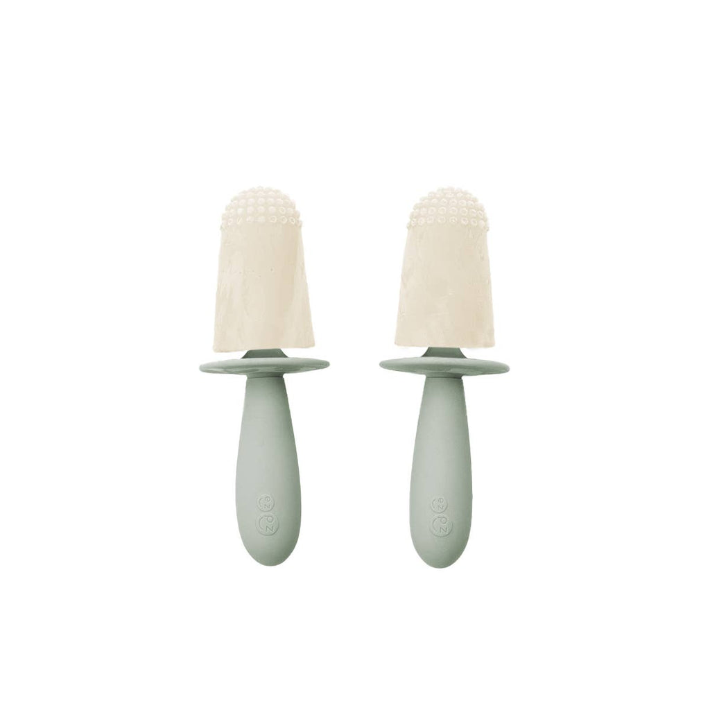 Two green baby soothers with beige silicone teats on a white background