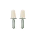 Two green baby soothers with beige silicone teats on a white background