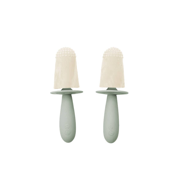 Two green baby soothers with beige silicone teats on a white background