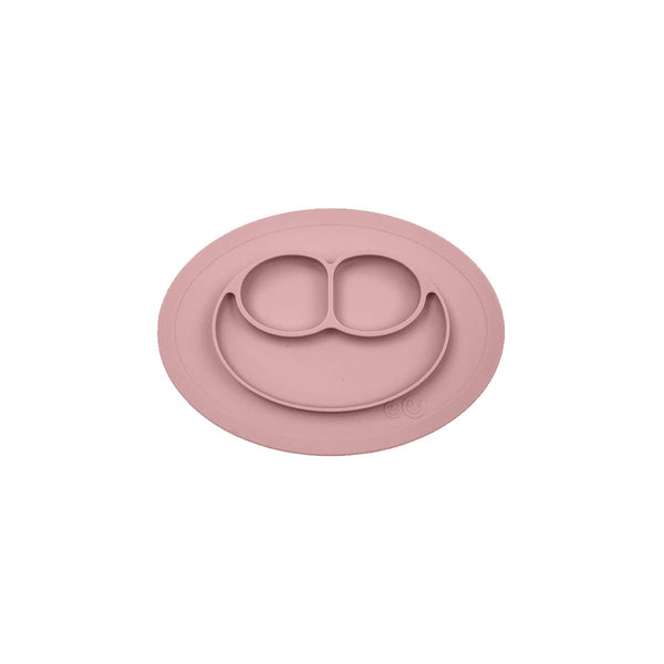 Pink silicone placemat with smiley face design on a white background