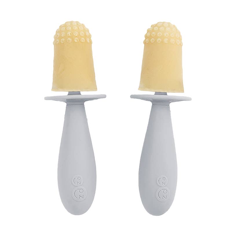 Two baby soothers with yellow silicone tips on a white background