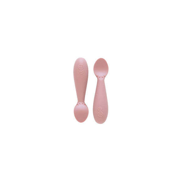 Two pink baby spoons on a white background