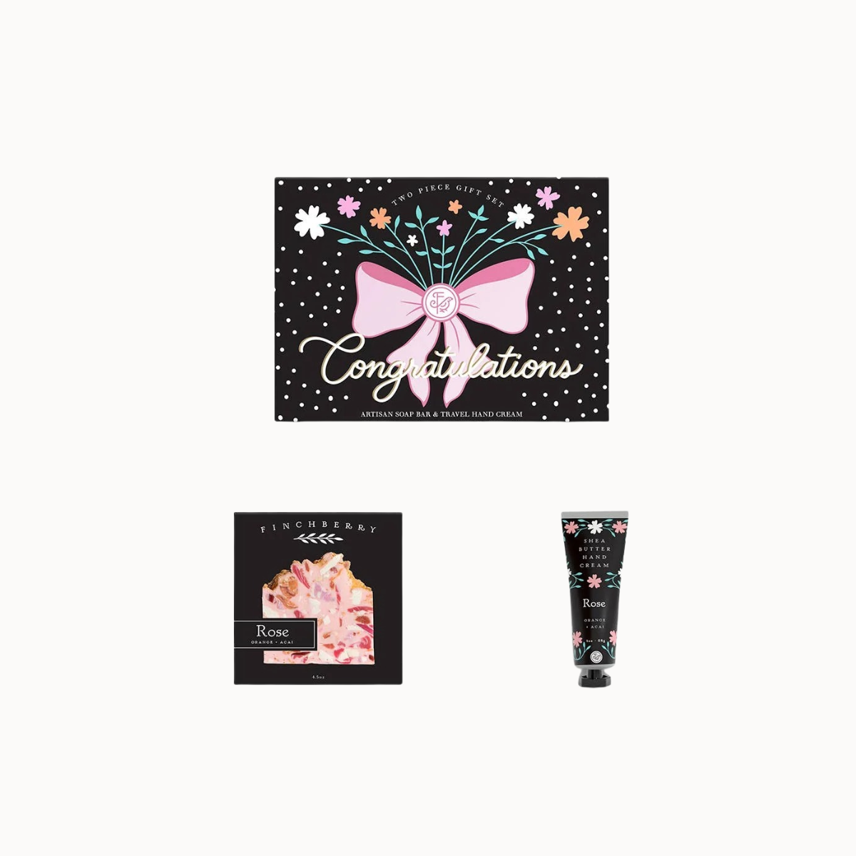 A three-piece Lindberghy gift set on a light gray background, featuring a black polka-dot 'Congratulations' card with a pink bow illustration, a black and pink Rose body wash box, and a black and pink Rose hand cream tube.