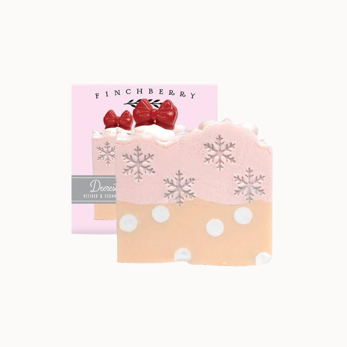 A decorative bath and body gift set featuring a pink and peach soap bar with white polka dots, silver snowflakes, and red bow details, shown in front of its pink packaging box labeled Finchberry.