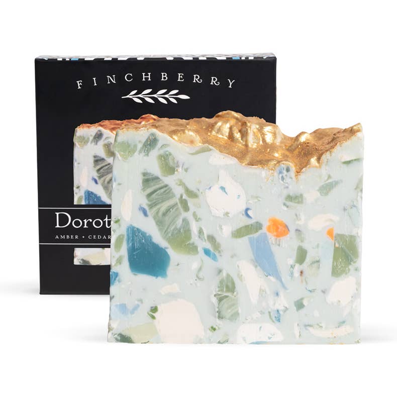 Decorative soap bar with gold top and visible ingredients, next to a black Finchberry branded box.