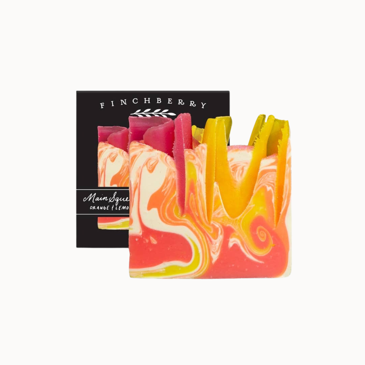 A colorful artisan soap bar with a marbled swirl pattern of pink, yellow, orange, and white, displayed in front of its black packaging box labeled 'FINCHBERRY' and 'Marmalage citrus limon'.