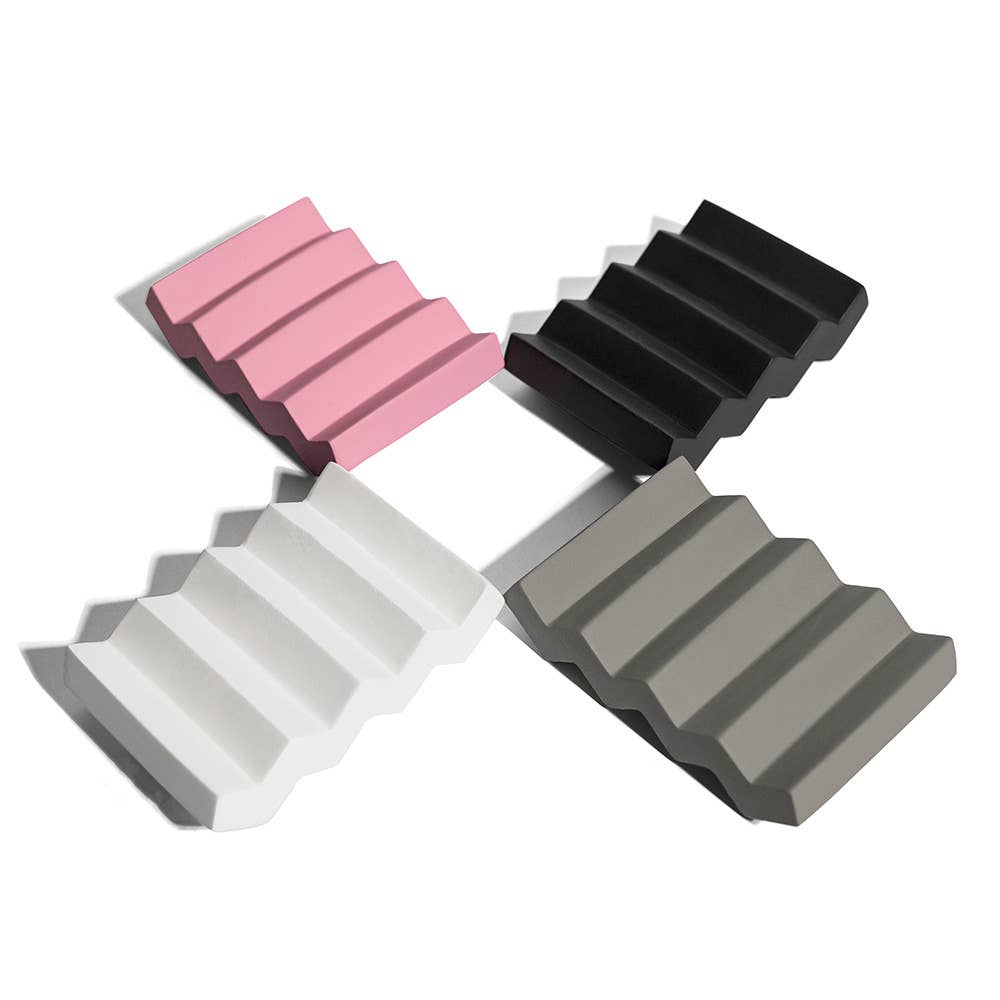 Four wedge-shaped blocks in pink, black, white, and gray on a white background