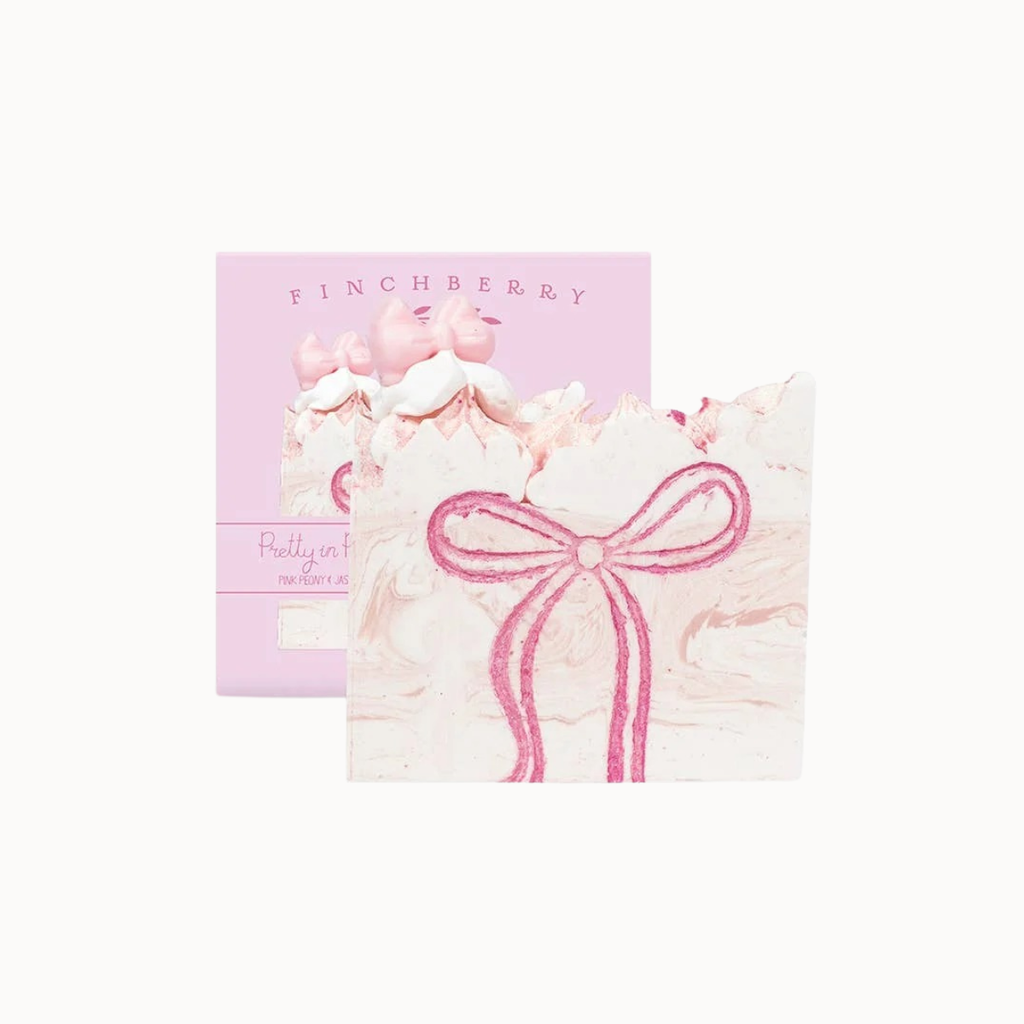 A pink Finchberry gift box with a matching decorative card in front, featuring a pink bow illustration and a small pig illustration, on a plain white background.
