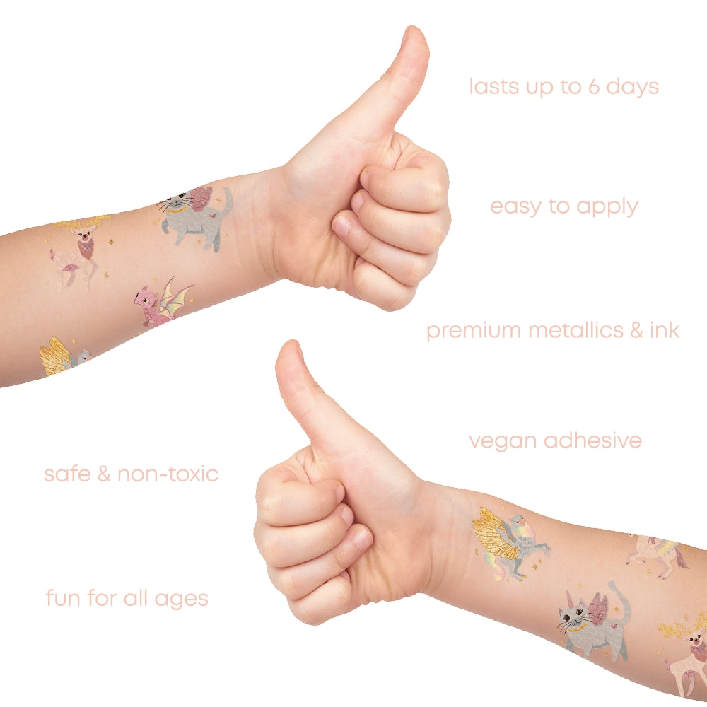 Children's arms with temporary tattoos of fairies, giving a thumbs up, on a white background.