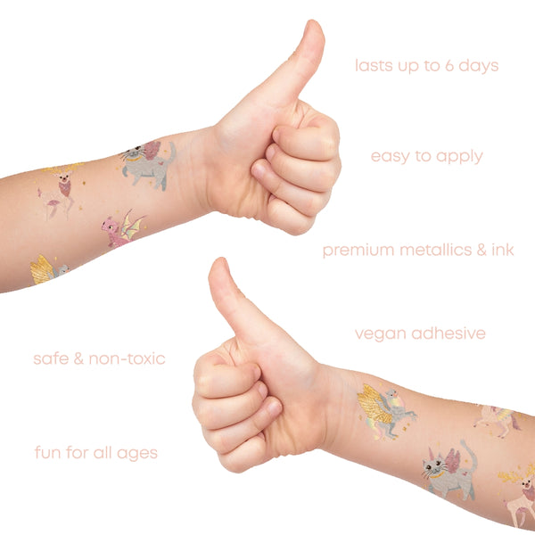 Children's arms with temporary tattoos of fairies, giving a thumbs up, on a white background.
