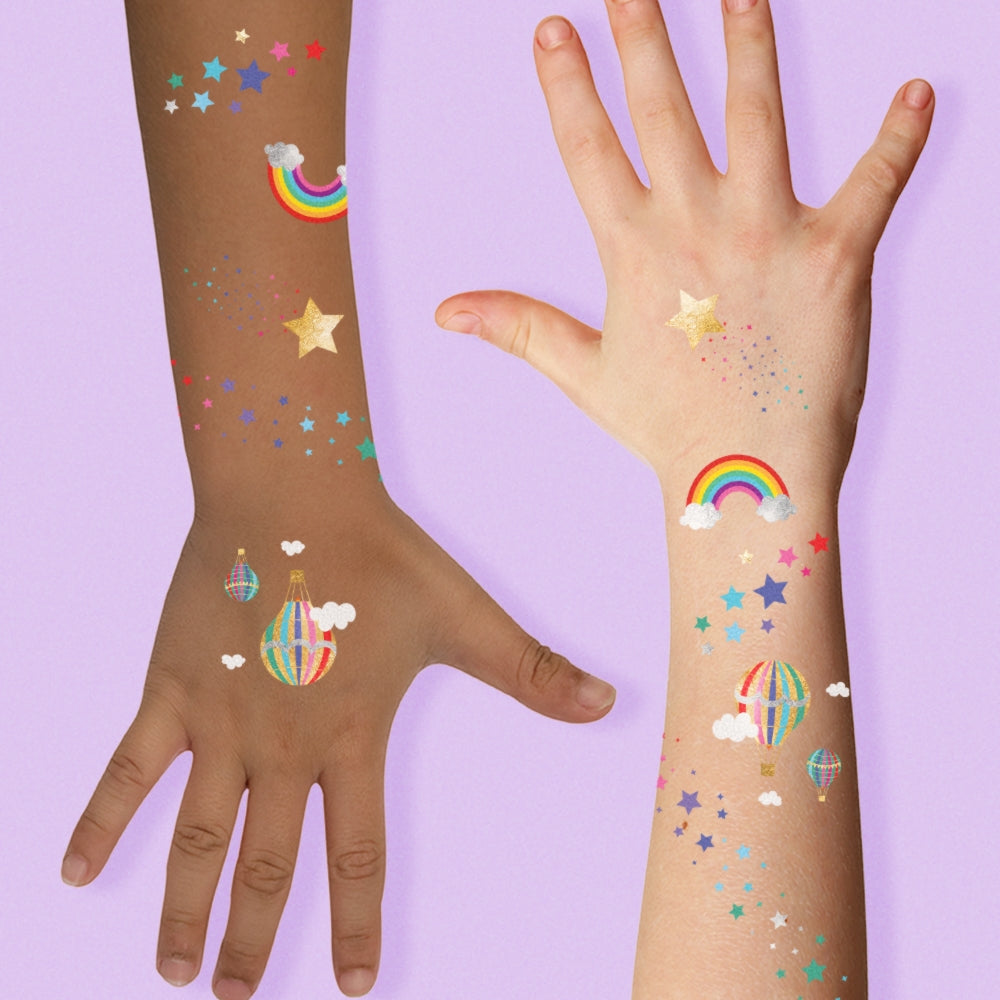 Two hands with colorful temporary tattoos on a purple background