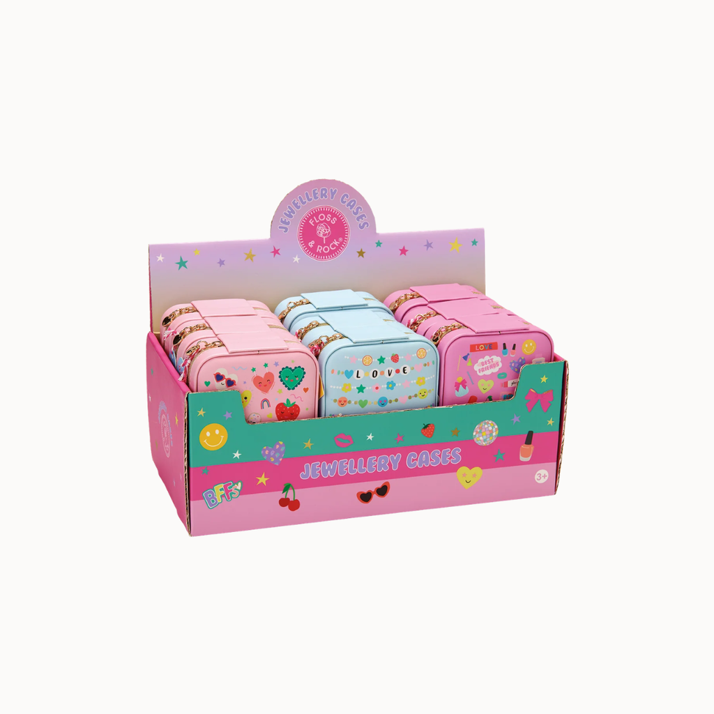 A pink cardboard retail display box holding multiple small round metal jewelry cases. The cases are decorated with colorful illustrations and text such as 'LOVE', 'JEWELLERY CASES', and 'STRAWBERRY CREAM'.