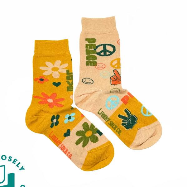 Two pairs of socks with peace signs and floral designs on a white background.