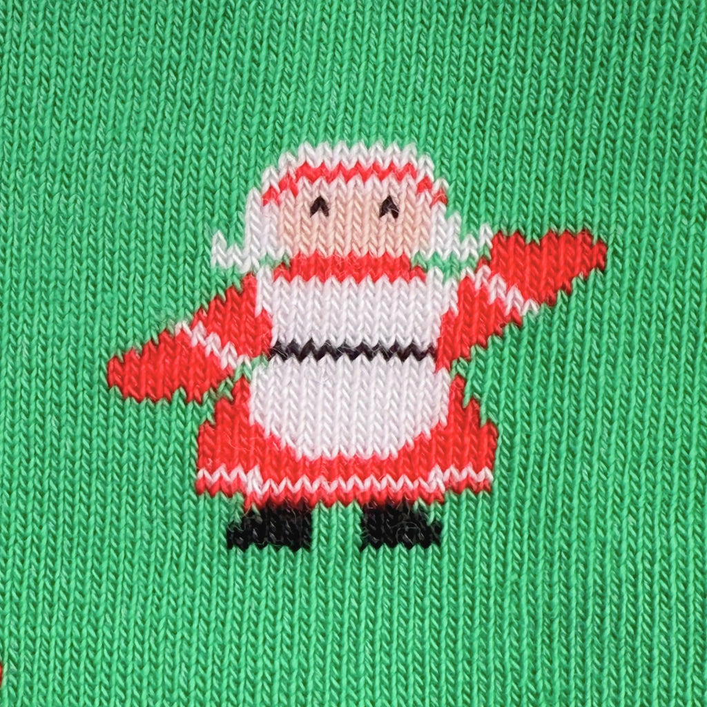 A close-up of a green knit fabric featuring a pixelated Santa Claus design in red, white, black, and gray.