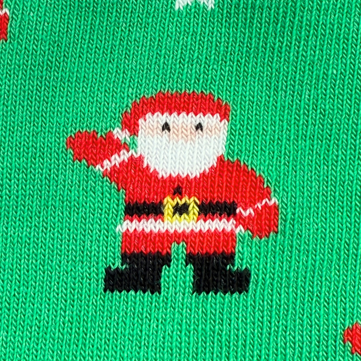 Close-up of a knitted Christmas sock featuring a pixelated Santa Claus figure on a bright green background.