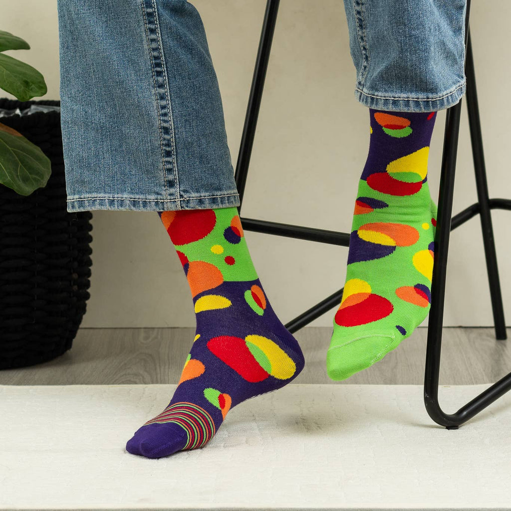 Colorful polka dot socks worn with jeans on a light background
