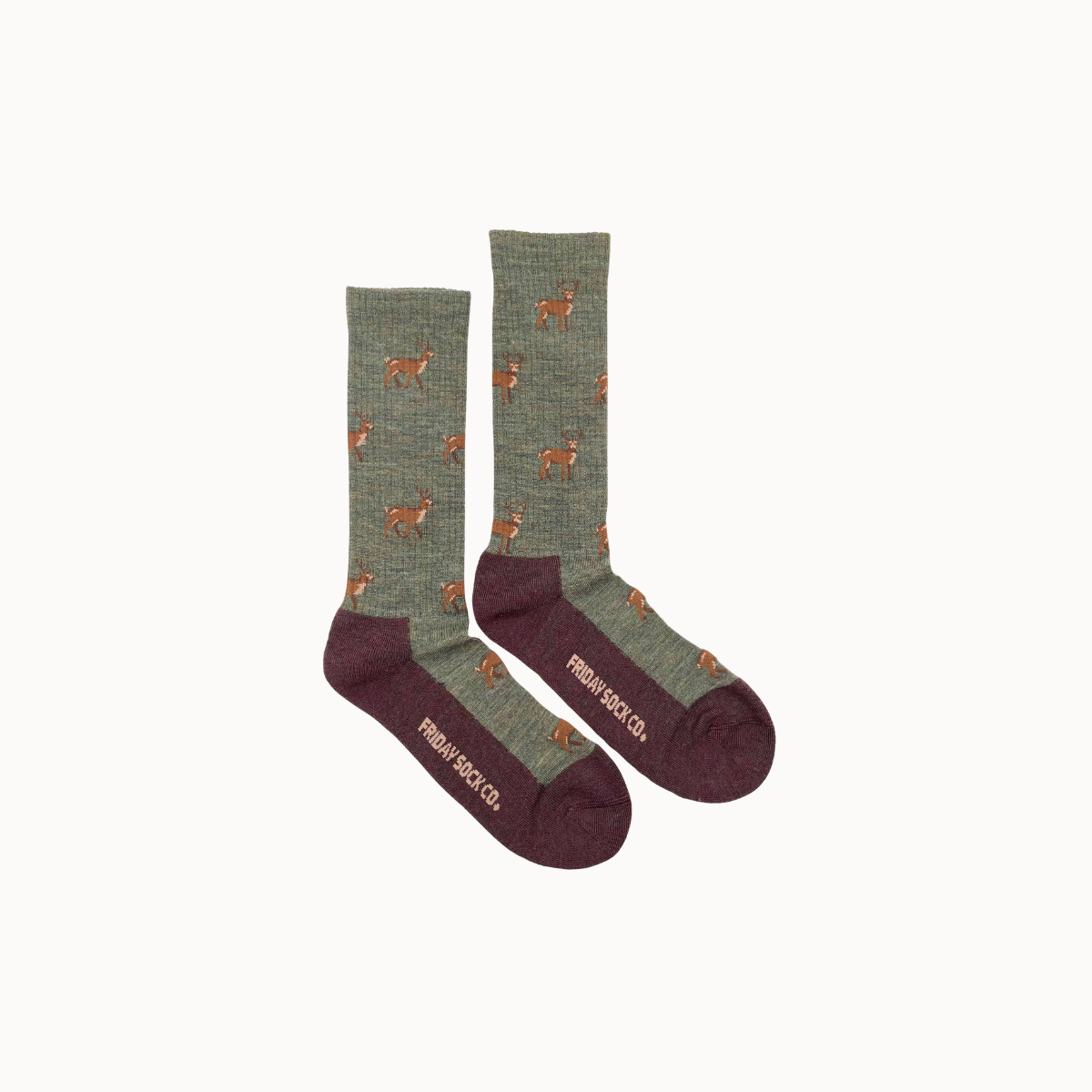 A pair of crew socks with a sage green heathered body, featuring a pattern of small brown deer and a dark burgundy heel, toe, and sole with the brand name 'friday sock CO.' printed in beige.