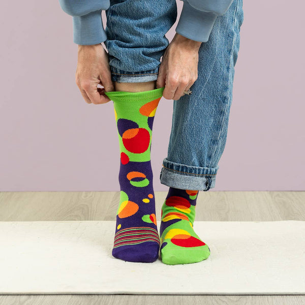 Person wearing colorful patterned socks with a plain background