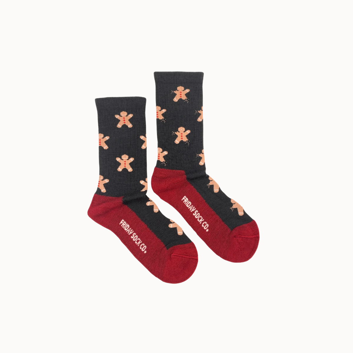 A pair of crew socks with a black upper leg section featuring a repeating gingerbread man pattern, a dark red foot, and white text reading 'friday sock co' on the side, shown on a light off-white background.