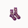 A pair of purple crew socks with a white, yellow, and pink floral pattern, displayed against a plain off-white background.