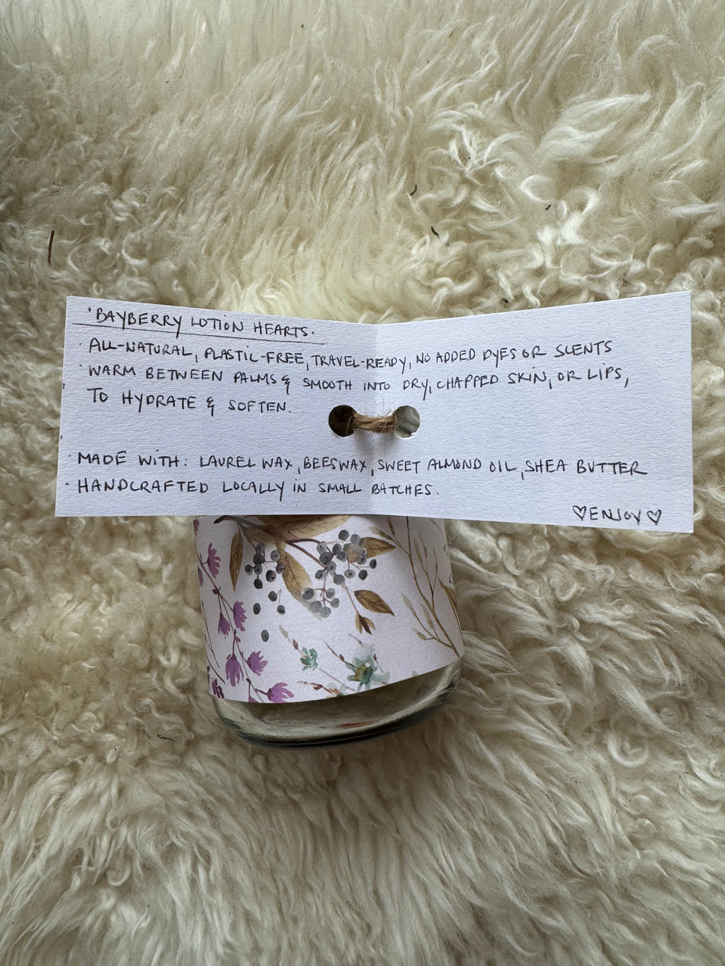 Roll of floral ribbon with a card on a fluffy white surface