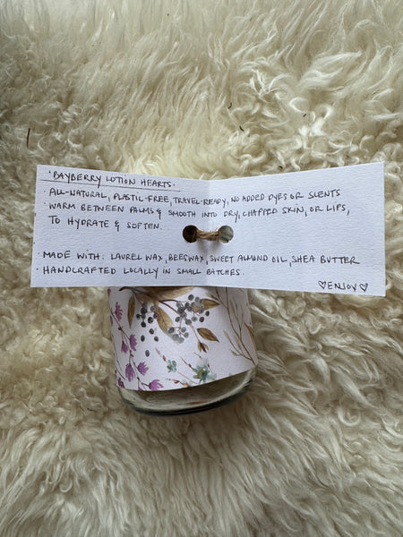 Roll of floral ribbon with a card on a fluffy white surface