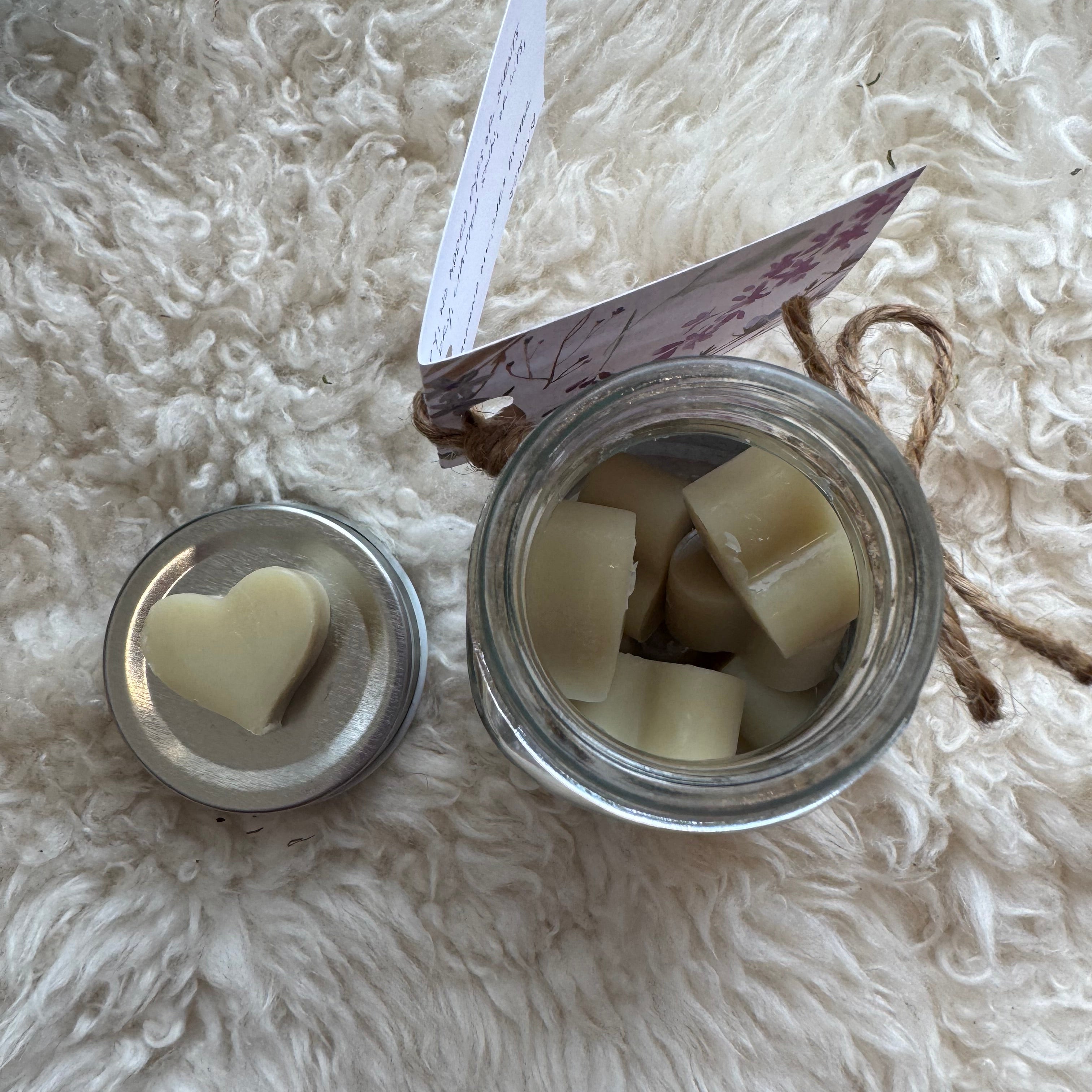 Jar with sliced white lotion drops on a fluffy white surface
