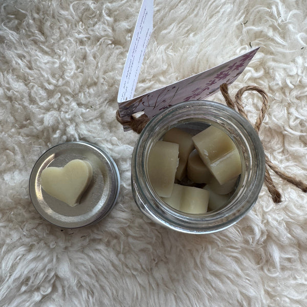 Jar with sliced white lotion drops on a fluffy white surface
