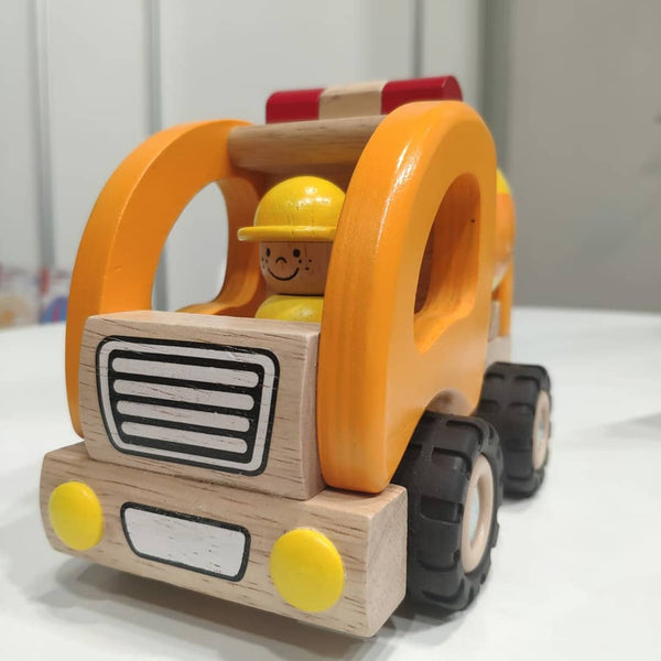 Wooden toy bulldozer with a smiling face on a white surface