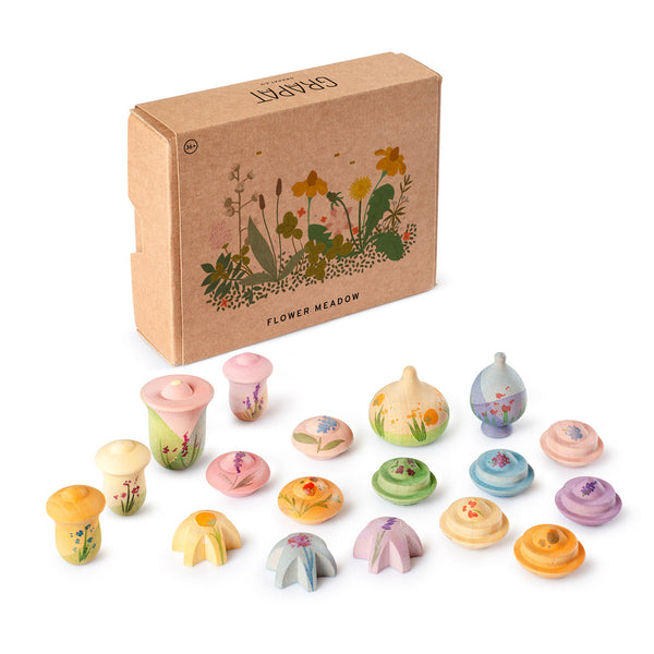Set of small, colorful wooden flowers in front of a cardboard box with floral design and 'GRAPAT' branding.