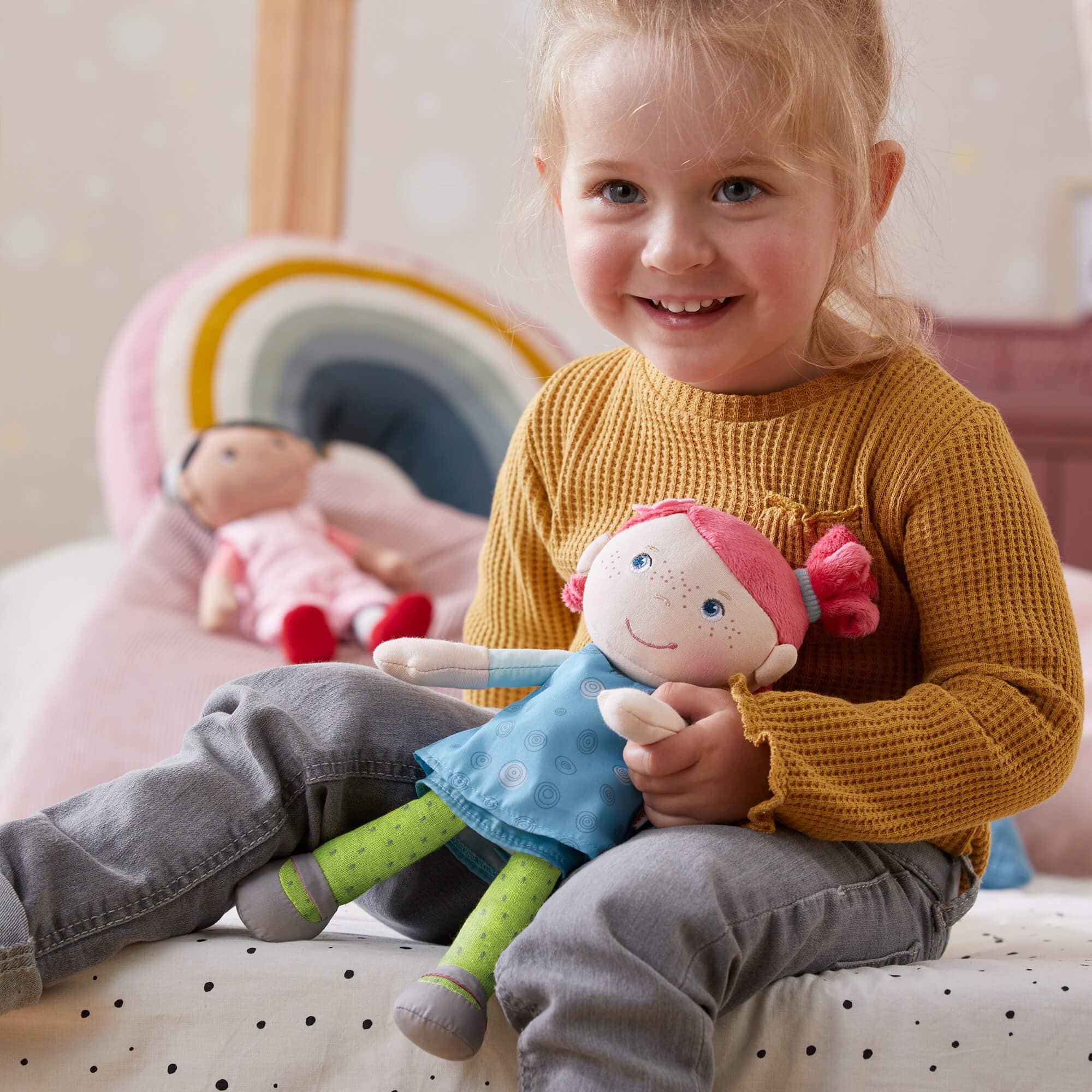 Child holding a plush toy with a colorful background