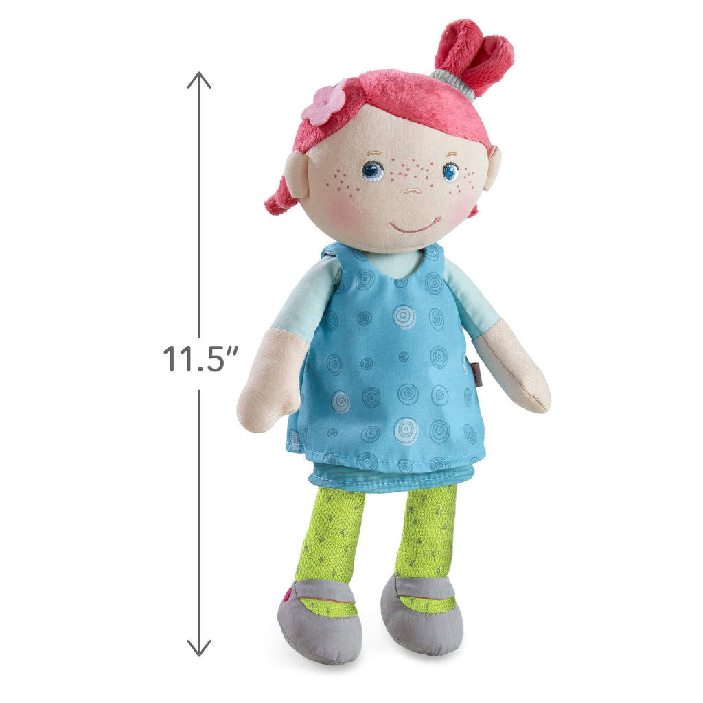 Stuffed doll with pink hair and a blue dress, standing next to a measurement label indicating 11.5 inches.