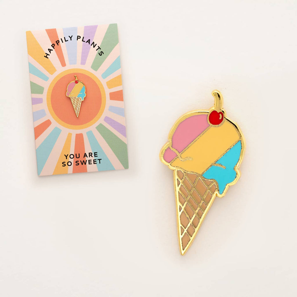 Ice cream cone-shaped pendant with a cherry on top, displayed in front of a colorful card.