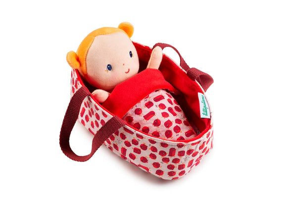 Toy doll in a red polka dot bag on a white background