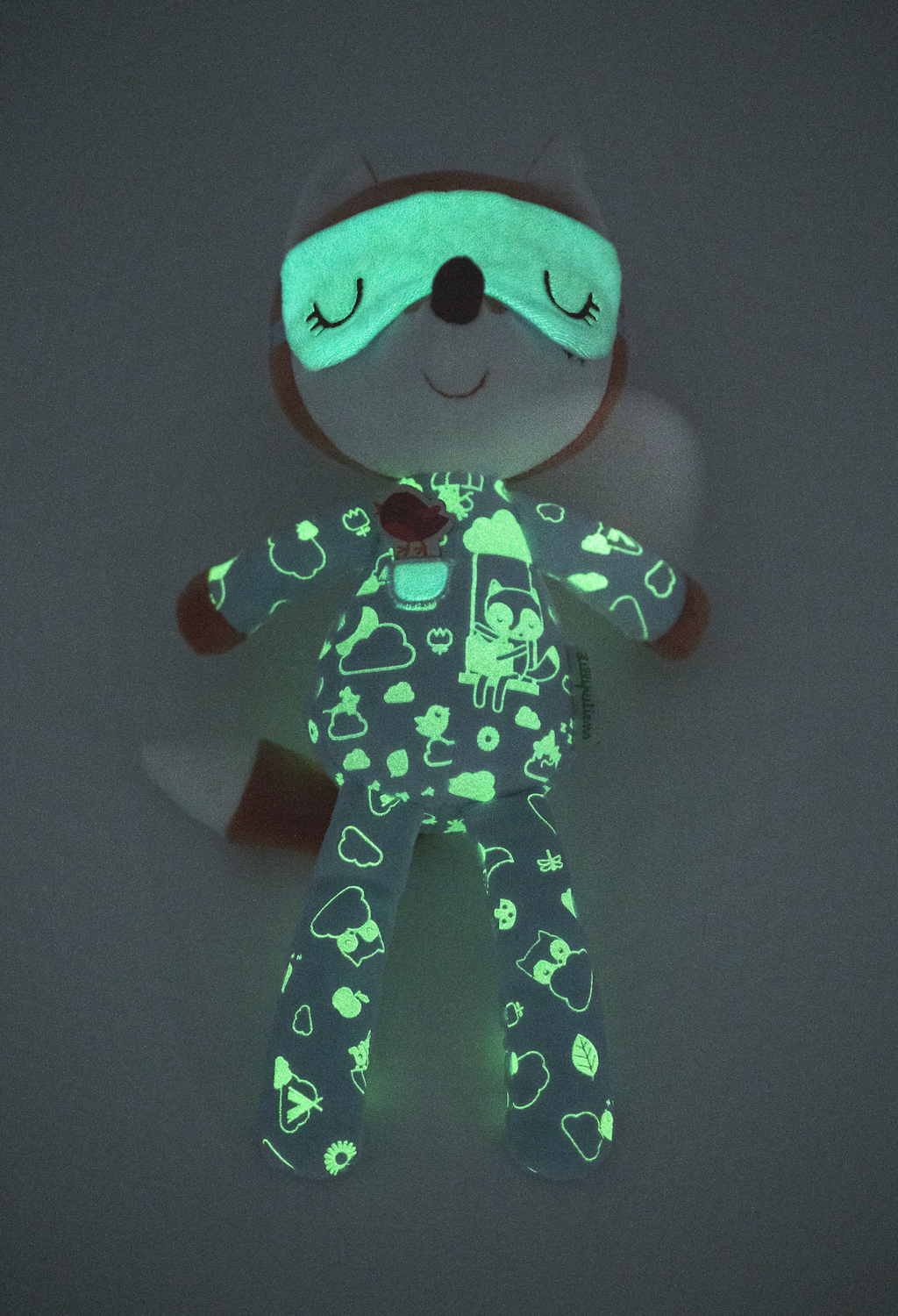 Glowing plush toy with animal design on a dark background
