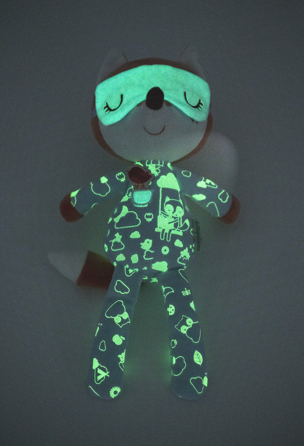 Glowing plush toy with animal design on a dark background