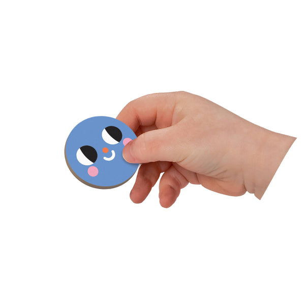 Hand holding a round blue object with cartoon face design on a white background