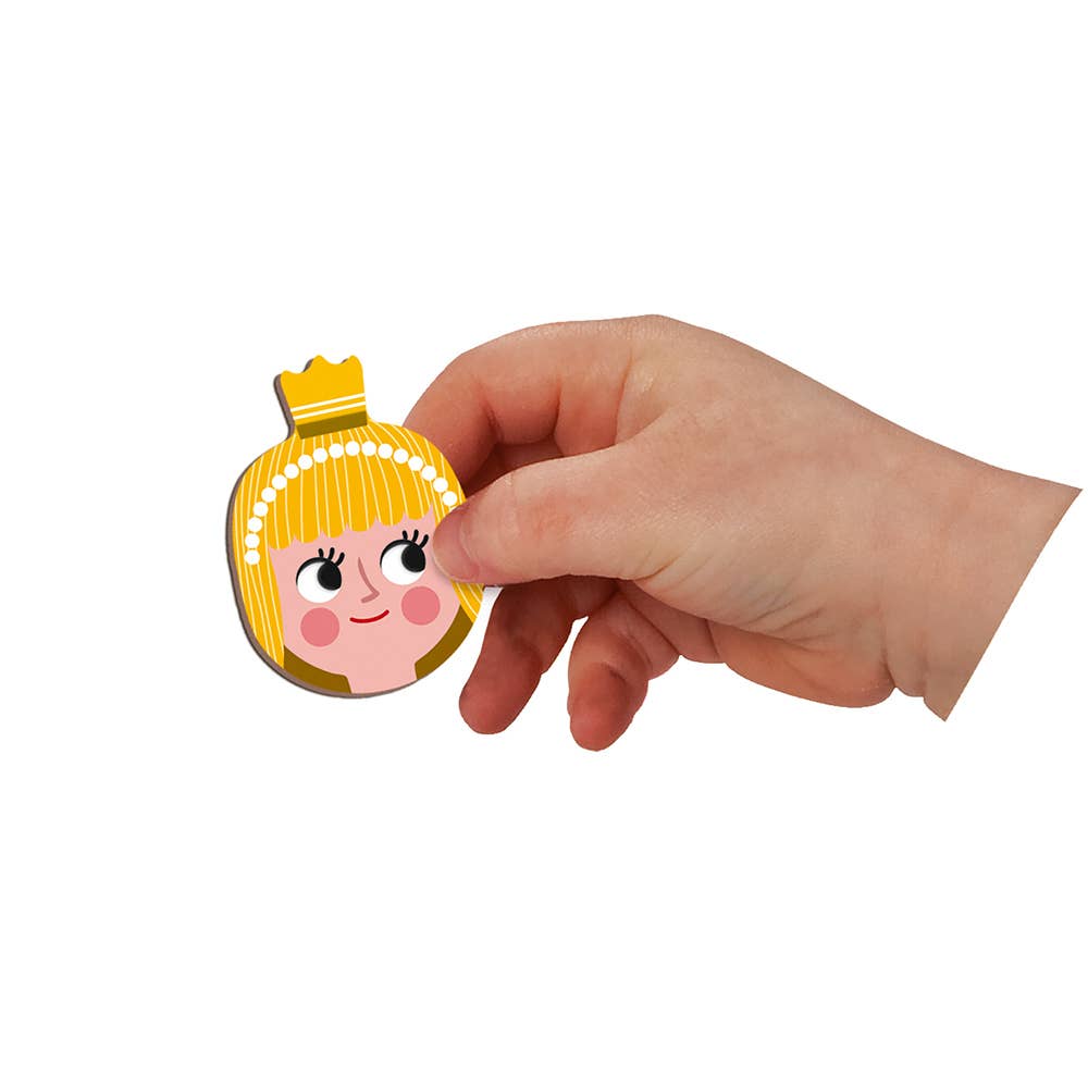 Hand holding a cartoon character keychain with blonde hair and a crown on a white background